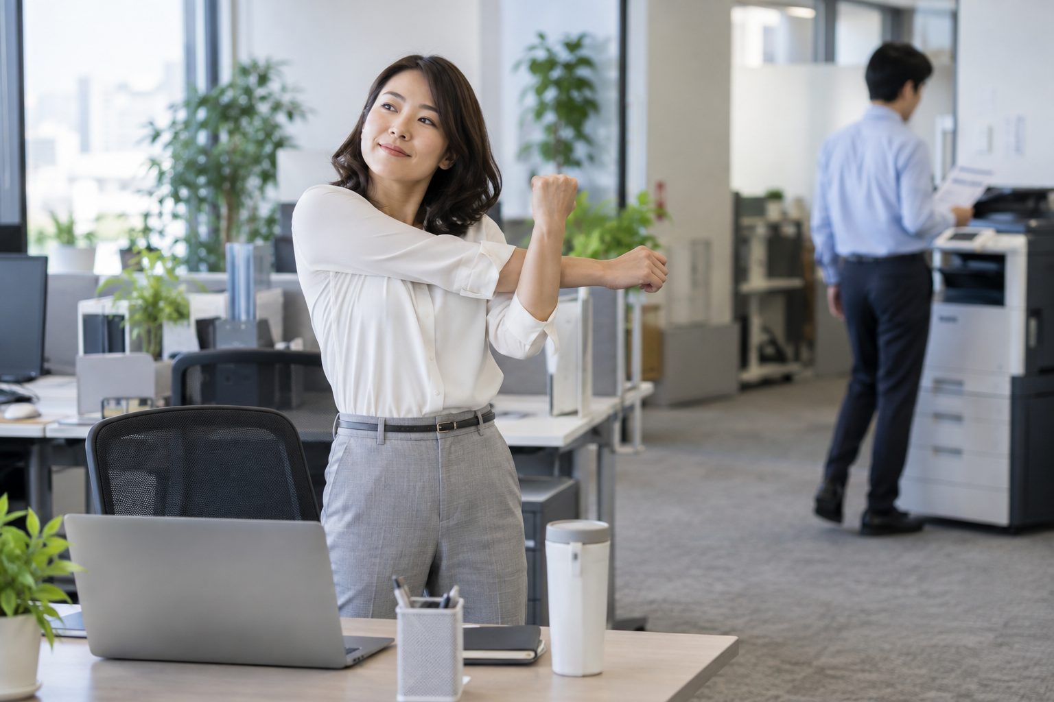 デスクの横で姿勢を変えて短い休憩をとる社員