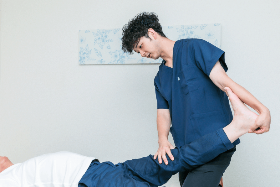 身体の状態を確認しながら施術を行うJourney Rehab代表・作業療法士の田中光