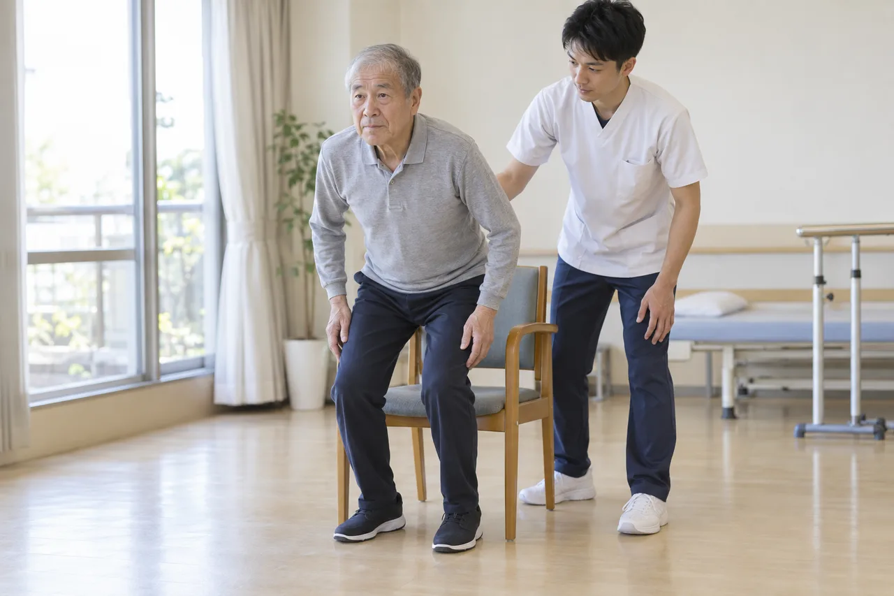 心臓血管手術前に見守り下で立ち座り練習を行う高齢者